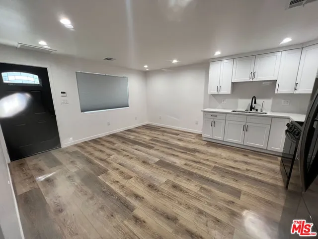 a large white kitchen with kitchen island a sink stainless steel appliances and cabinets