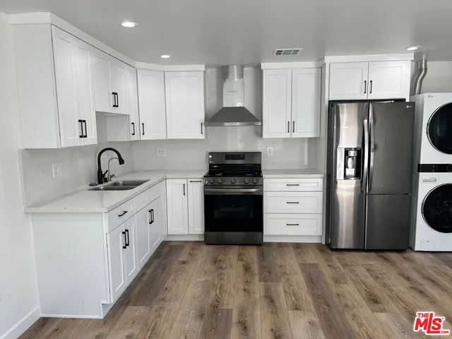 a kitchen with a refrigerator stove and white cabinets