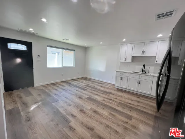 a view of a kitchen with wooden floor and a sink