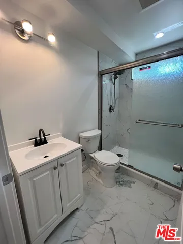 a bathroom with a sink a toilet and shower