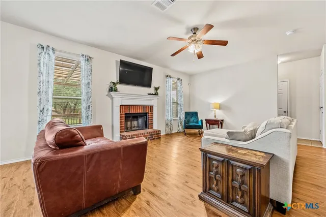 a living room with furniture a fireplace and a flat screen tv