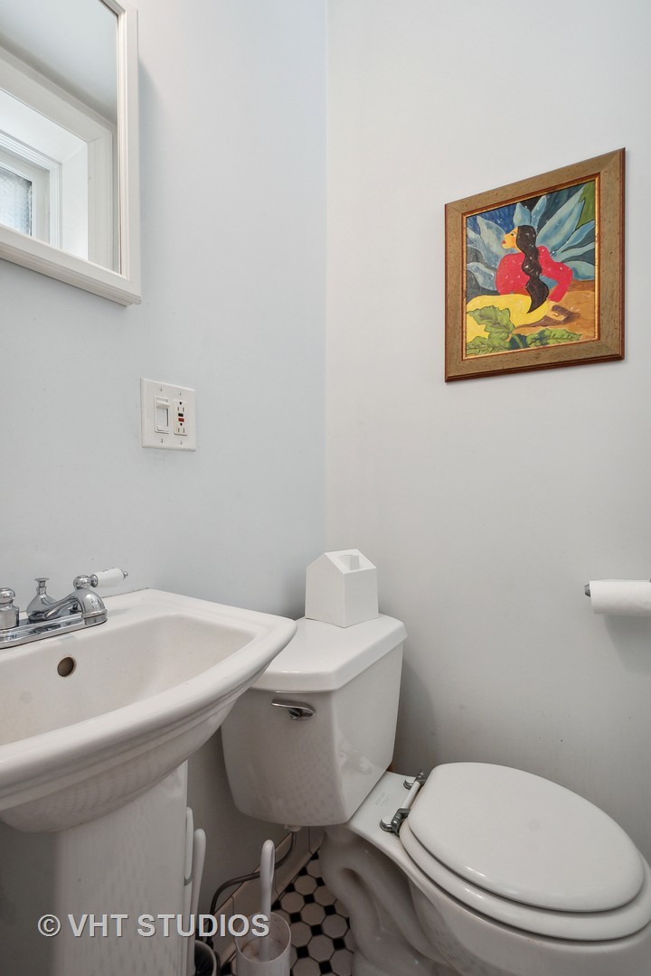 672 West Irving Park Road, Unit G1 Chicago, IL 60613 - Photo 14 of 19 a white toilet sitting next to a bathroom sink