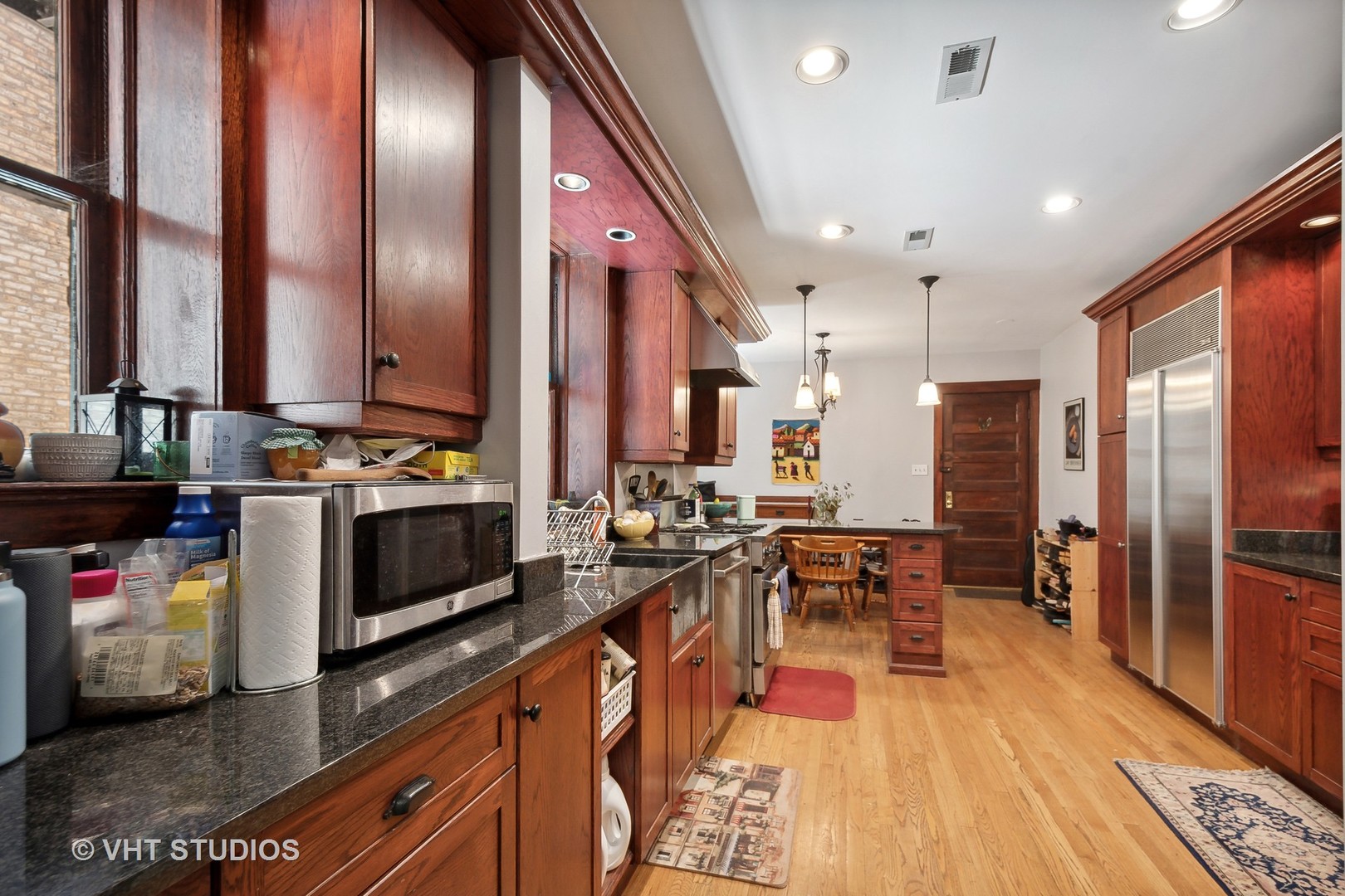 672 West Irving Park Road, Unit G1 Chicago, IL 60613 - Photo 8 of 19 a kitchen with stainless steel appliances kitchen island granite countertop a stove a sink and a refrigerator
