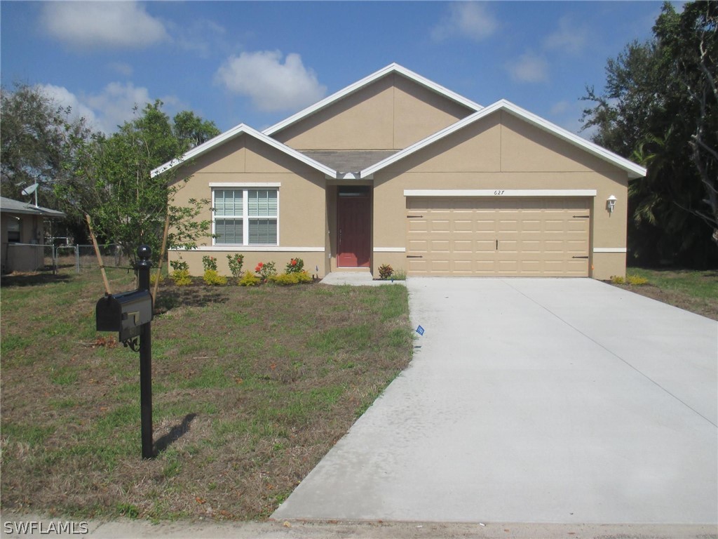 627 Southwest 28th Street Cape Coral, FL 33914 - Photo 1 of 8 a front view of a house with a yard and garage