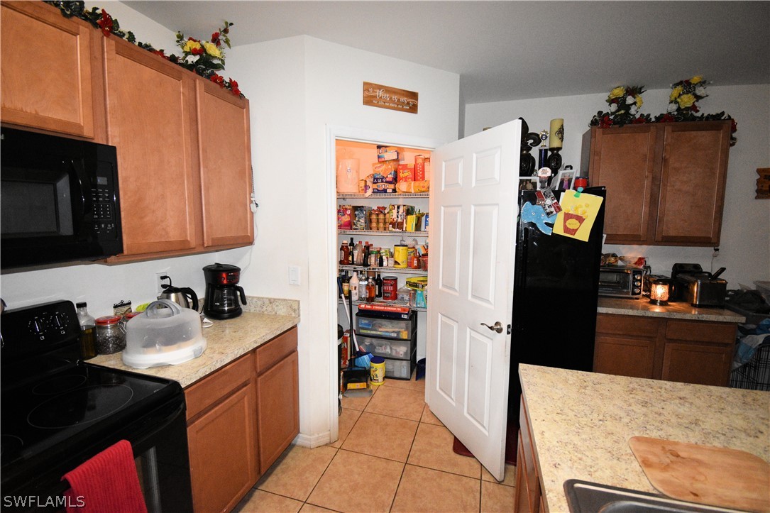 627 Southwest 28th Street Cape Coral, FL 33914 - Photo 2 of 8 a kitchen with a refrigerator and a stove top oven