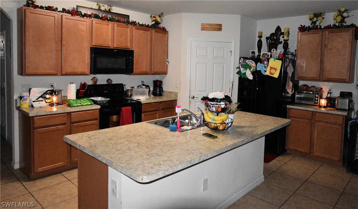 627 Southwest 28th Street Cape Coral, FL 33914 - Photo 3 of 8 a kitchen with stainless steel appliances granite countertop a sink wooden cabinets and a granite counter tops