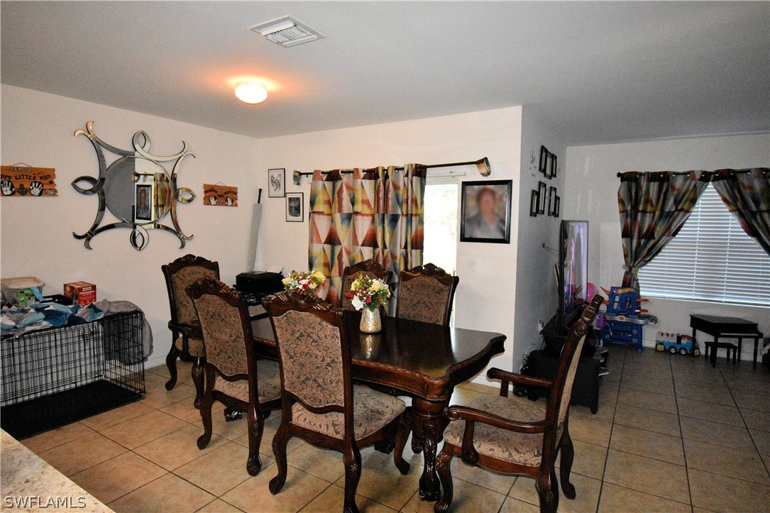 627 Southwest 28th Street Cape Coral, FL 33914 - Photo 4 of 8 a view of a dining room with furniture and wooden floor