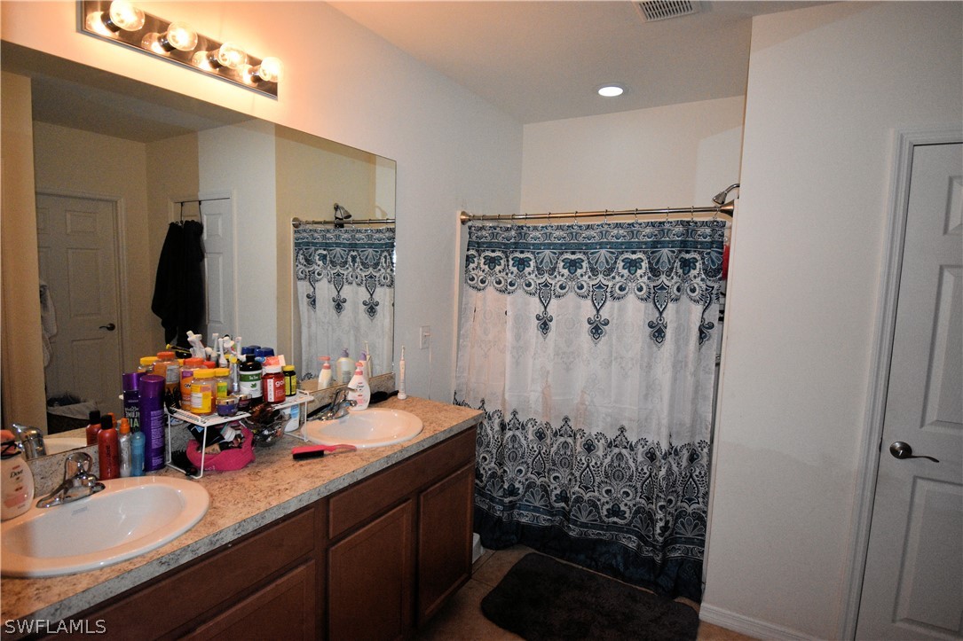 627 Southwest 28th Street Cape Coral, FL 33914 - Photo 6 of 8 a bathroom with a sink double vanity and a mirror