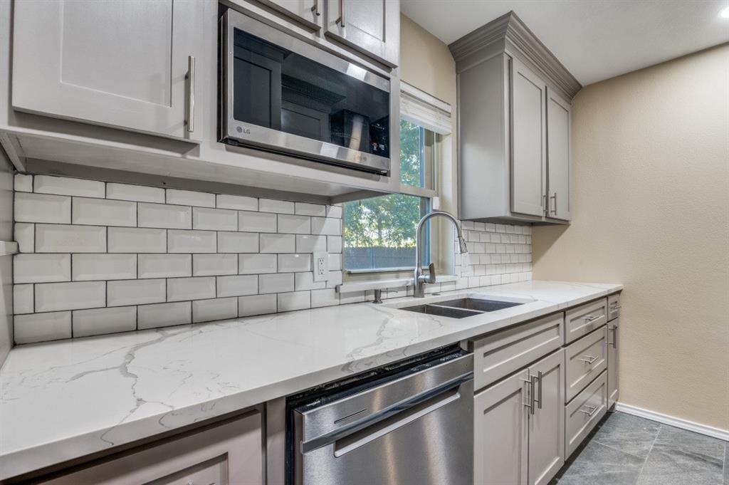 628 Thompson Street Everman, TX 76140 - Photo 12 of 24 a kitchen with a sink cabinets and microwave