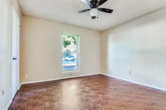an empty room with a window and a fan