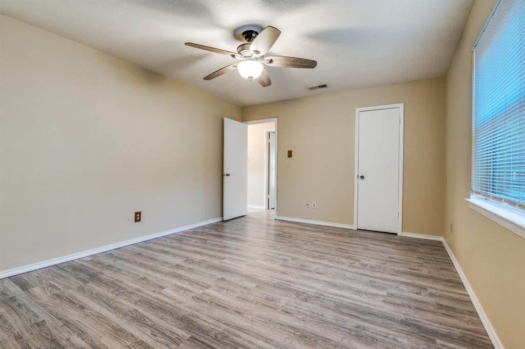 628 Thompson Street Everman, TX 76140 - Photo 17 of 24 wooden floor in an empty room with a window