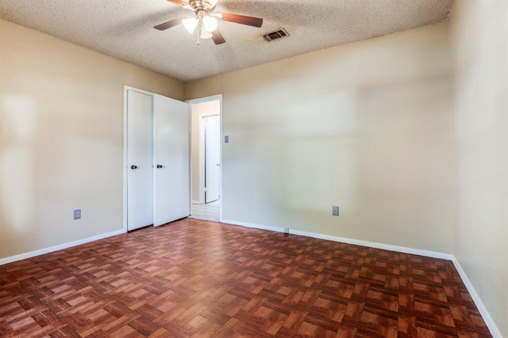 628 Thompson Street Everman, TX 76140 - Photo 19 of 24 an empty room with a chandelier fan and windows
