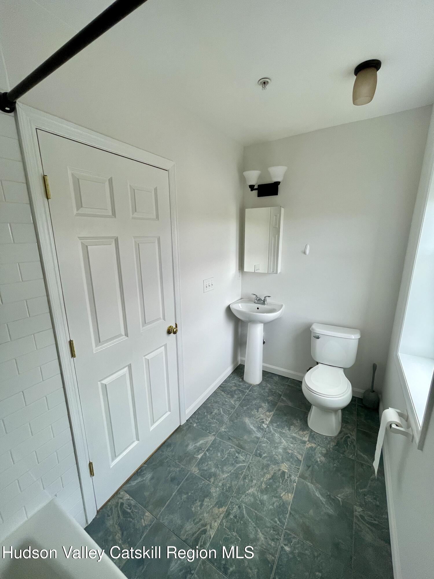 202 Warren Street, Unit 2 Hudson, NY 12534 - Photo 14 of 17 a white toilet sitting next to a bathroom sink