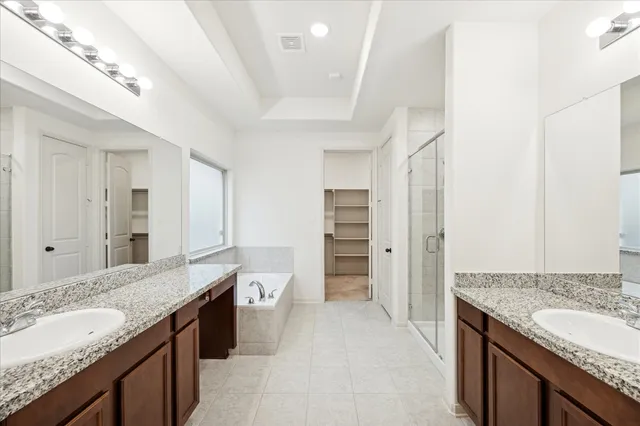 a bathroom with a granite countertop sink a mirror and a bathtub