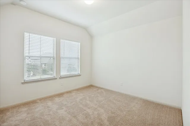 an empty room with a ceiling fan and window