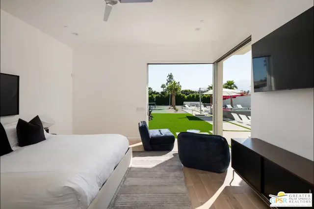a bed room with a bed television and a large window
