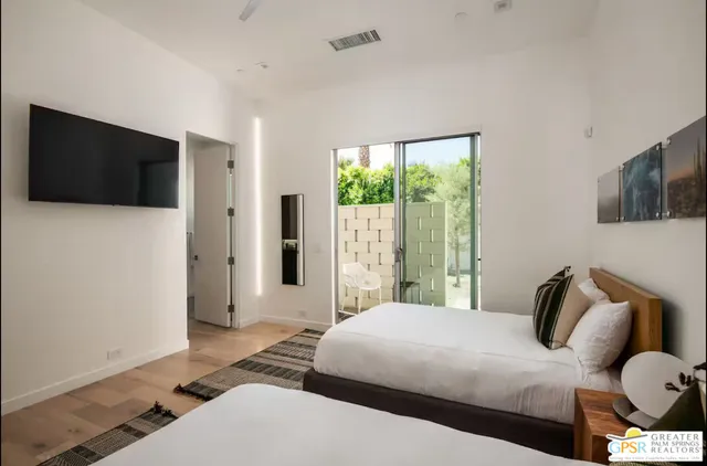 a bedroom with a bed and flat screen tv