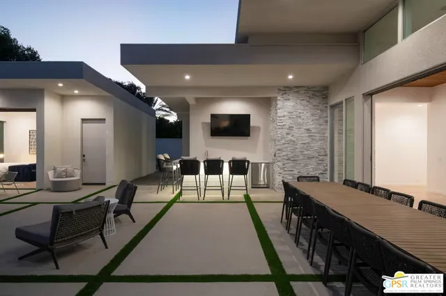 a living room with patio furniture and a flat screen tv