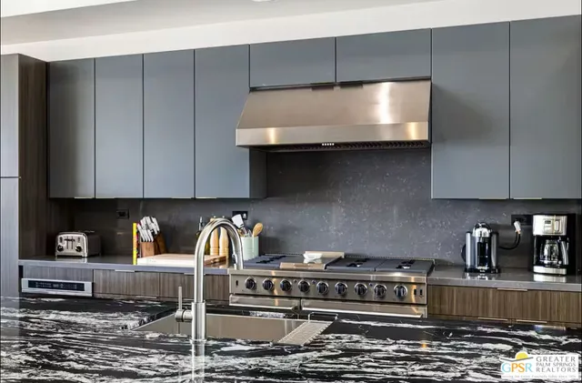 a kitchen with granite countertop a stove and a sink