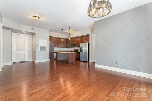 a view of a kitchen with a sink and dishwasher a refrigerator with wooden floor