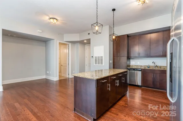 a kitchen with stainless steel appliances granite countertop a sink a stove and a refrigerator