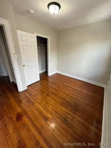 an empty room with wooden floor and door
