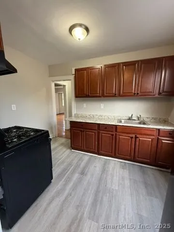 a kitchen with granite countertop wooden cabinets and black appliances