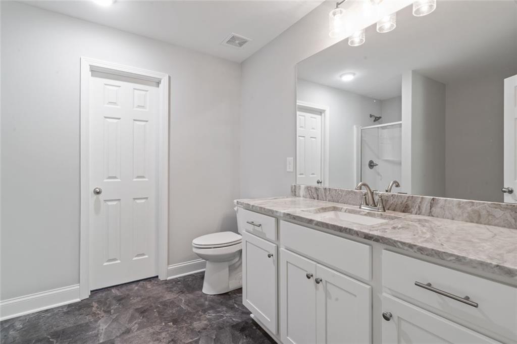 2707 Hickory Lane Dawsonville, GA 30534 - Photo 23 of 31 a bathroom with a granite countertop sink toilet and mirror