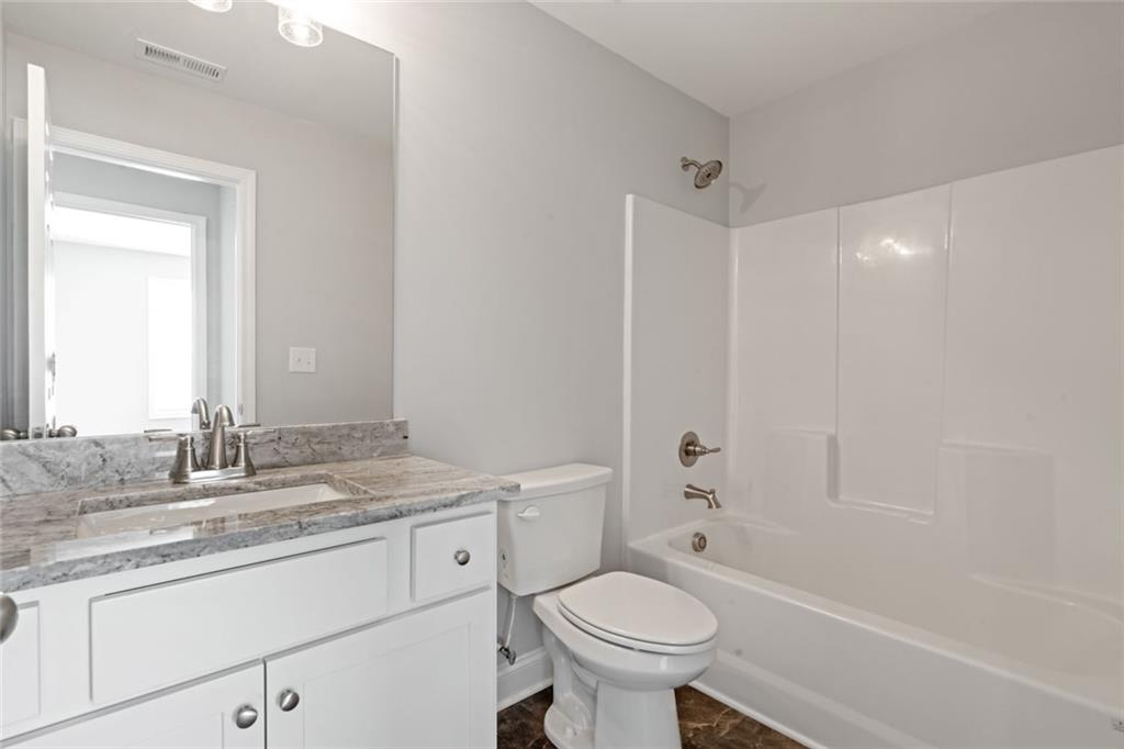 2707 Hickory Lane Dawsonville, GA 30534 - Photo 27 of 31 a bathroom with a granite countertop sink toilet mirror and bathtub