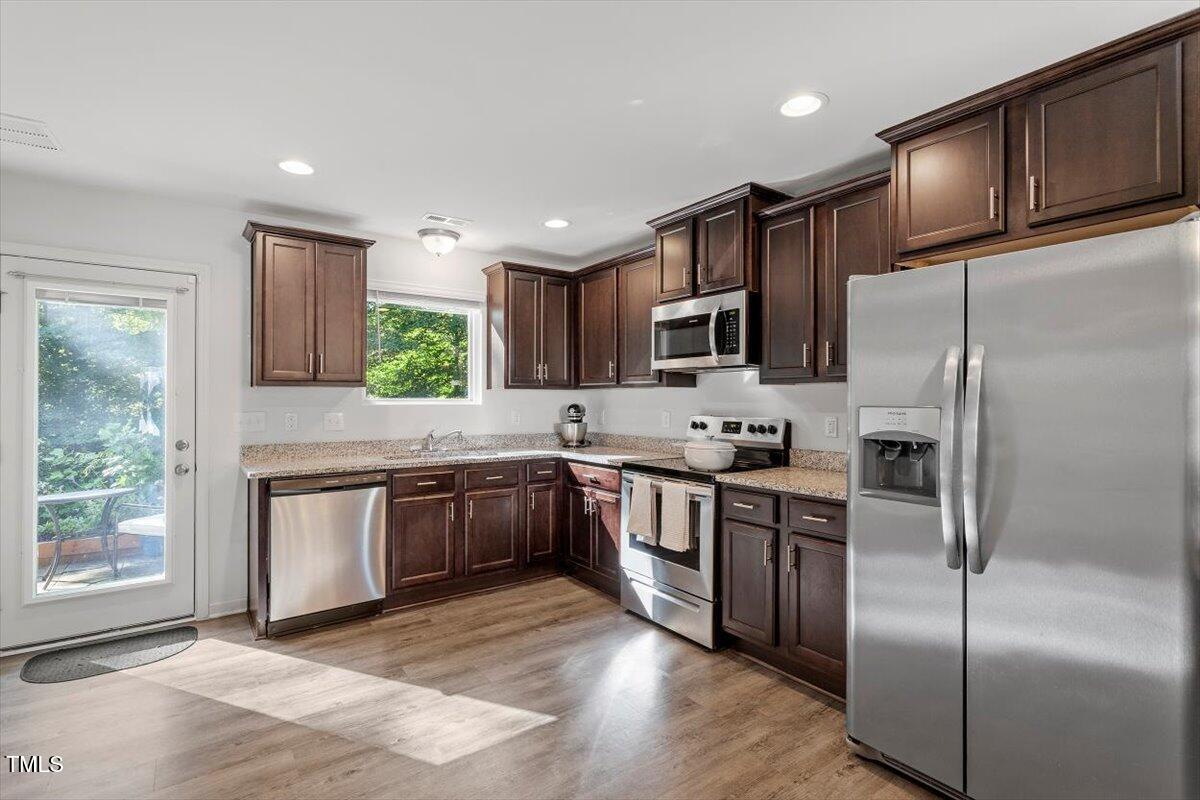 534 Hobkirks Place Durham, NC 27704 - Photo 17 of 34 a kitchen with granite countertop stainless steel appliances cabinets a sink and a window