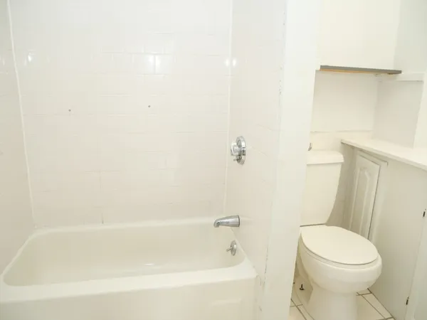 a white bath tub sitting next to a white toilet