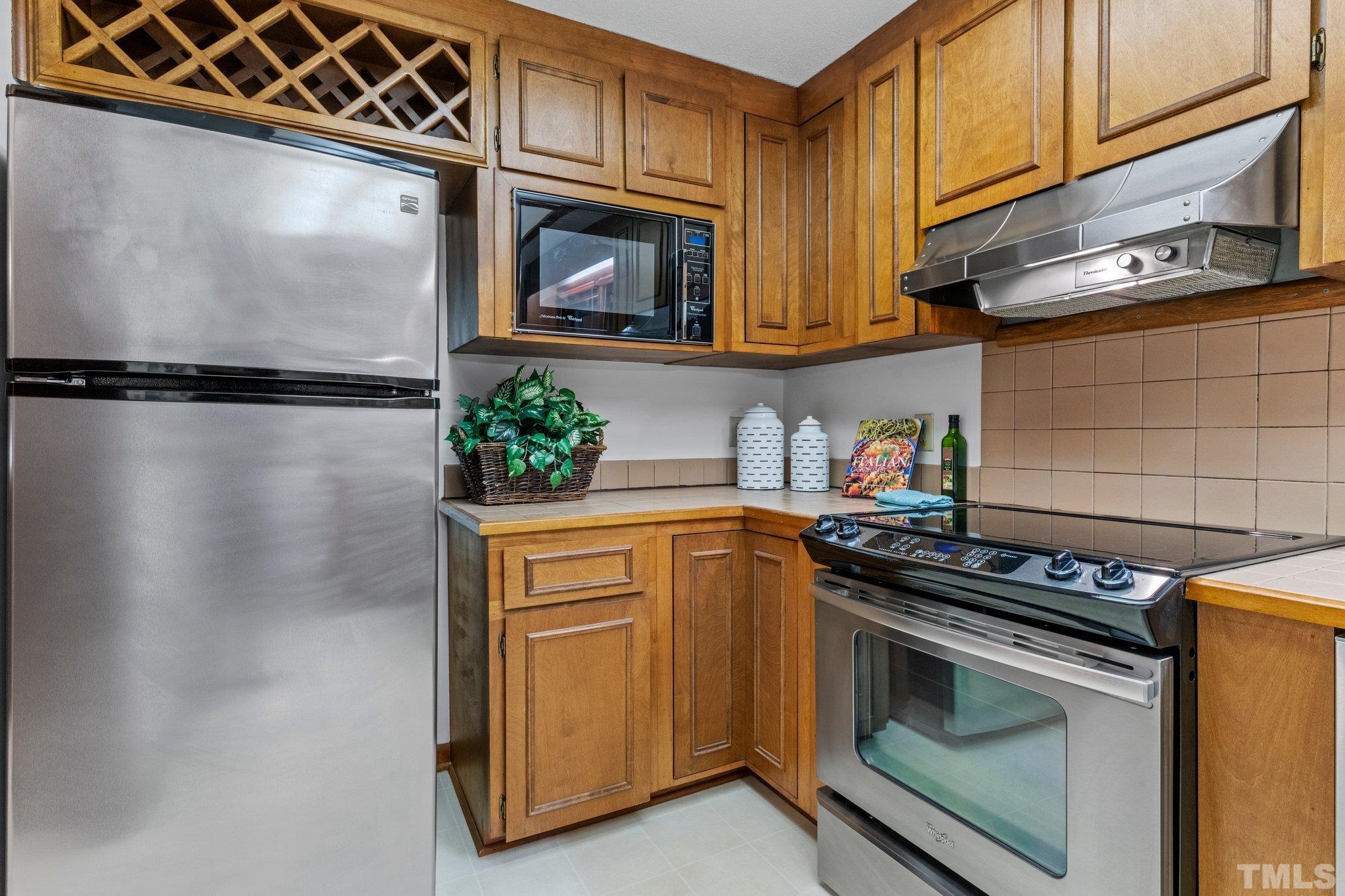 7829 Breckon Way Raleigh, NC 27615 - Photo 12 of 40 a kitchen with stainless steel appliances granite countertop a refrigerator and a stove top oven