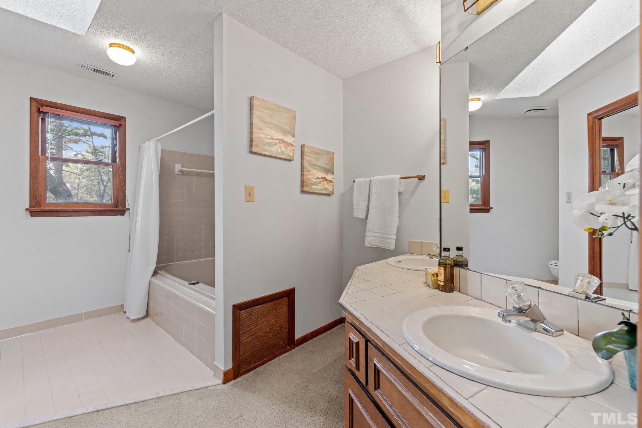 7829 Breckon Way Raleigh, NC 27615 - Photo 18 of 40 a bathroom with 2 sink and a mirror