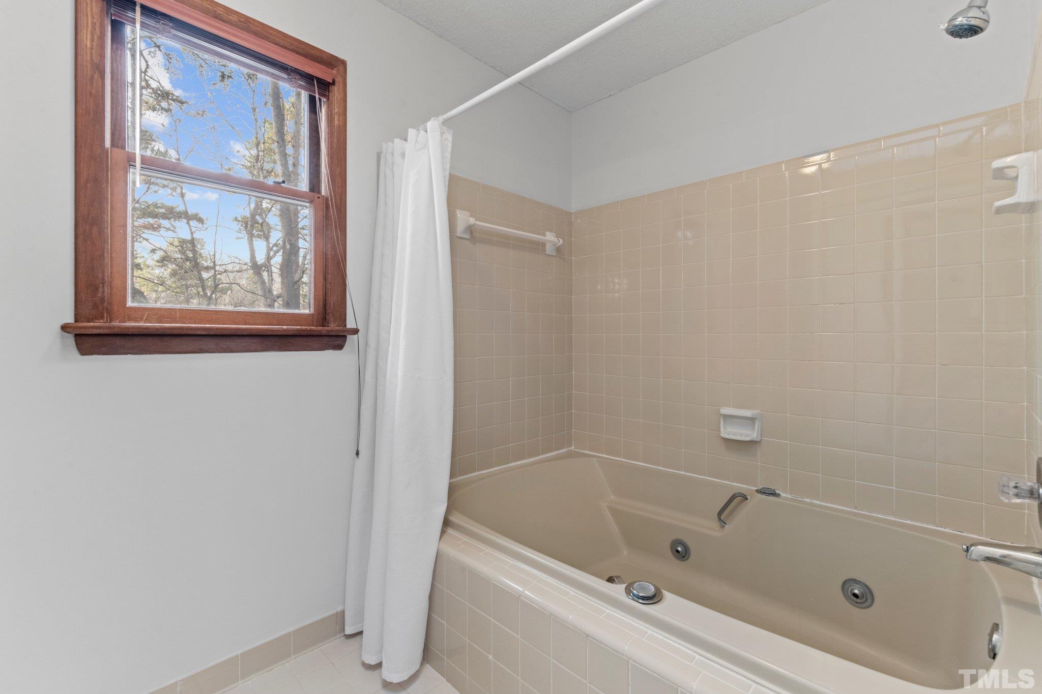 7829 Breckon Way Raleigh, NC 27615 - Photo 19 of 40 a white bath tub sitting next to a shower