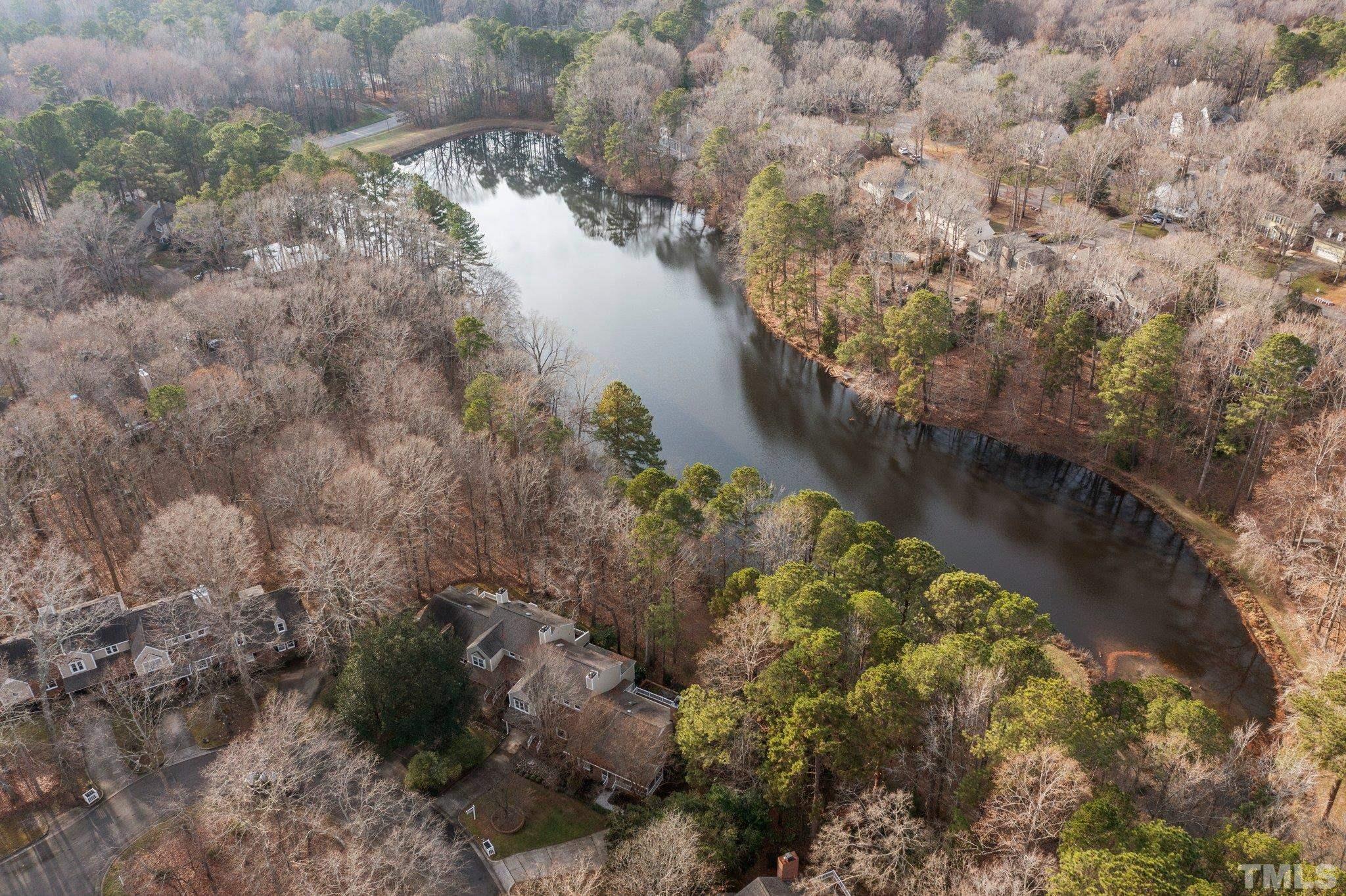 7829 Breckon Way Raleigh, NC 27615 - Photo 33 of 40 a view of a lake with a yard and large trees