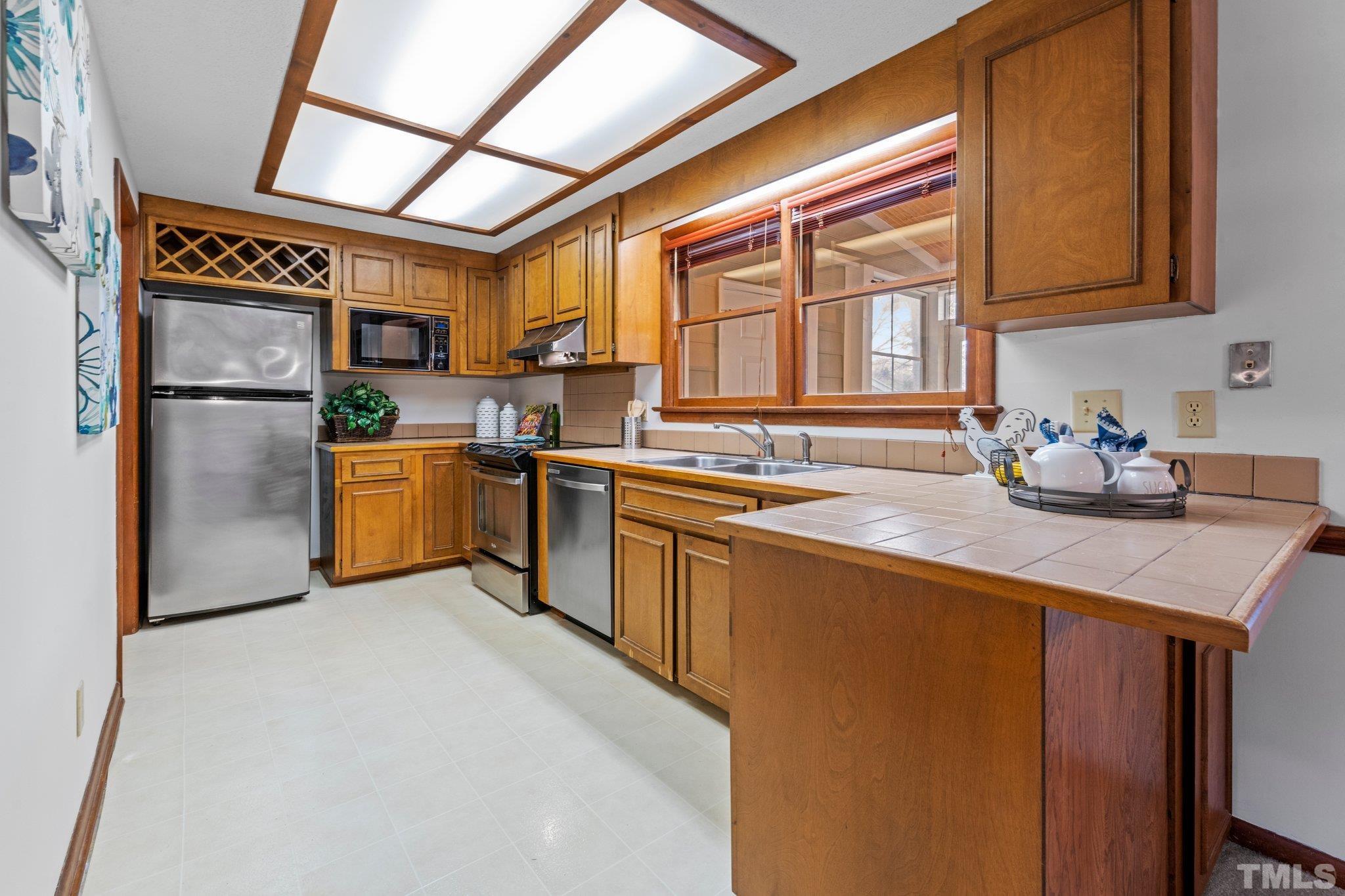 7829 Breckon Way Raleigh, NC 27615 - Photo 10 of 40 a kitchen with stainless steel appliances granite countertop a sink stove and refrigerator
