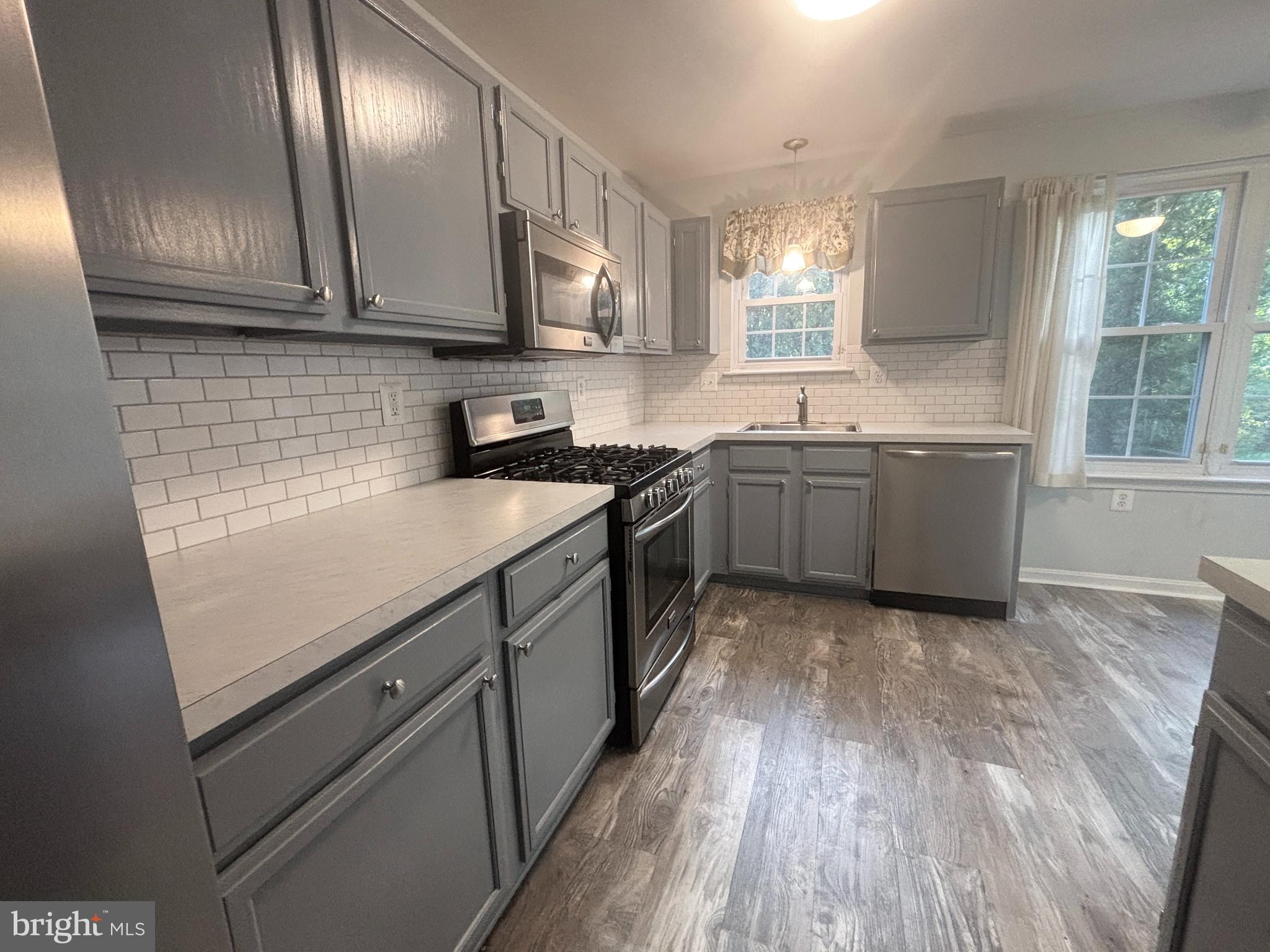 307 Tall Pines Court, Unit 3 Abingdon, MD 21009 - Photo 13 of 52 a kitchen with a sink a stove and cabinets