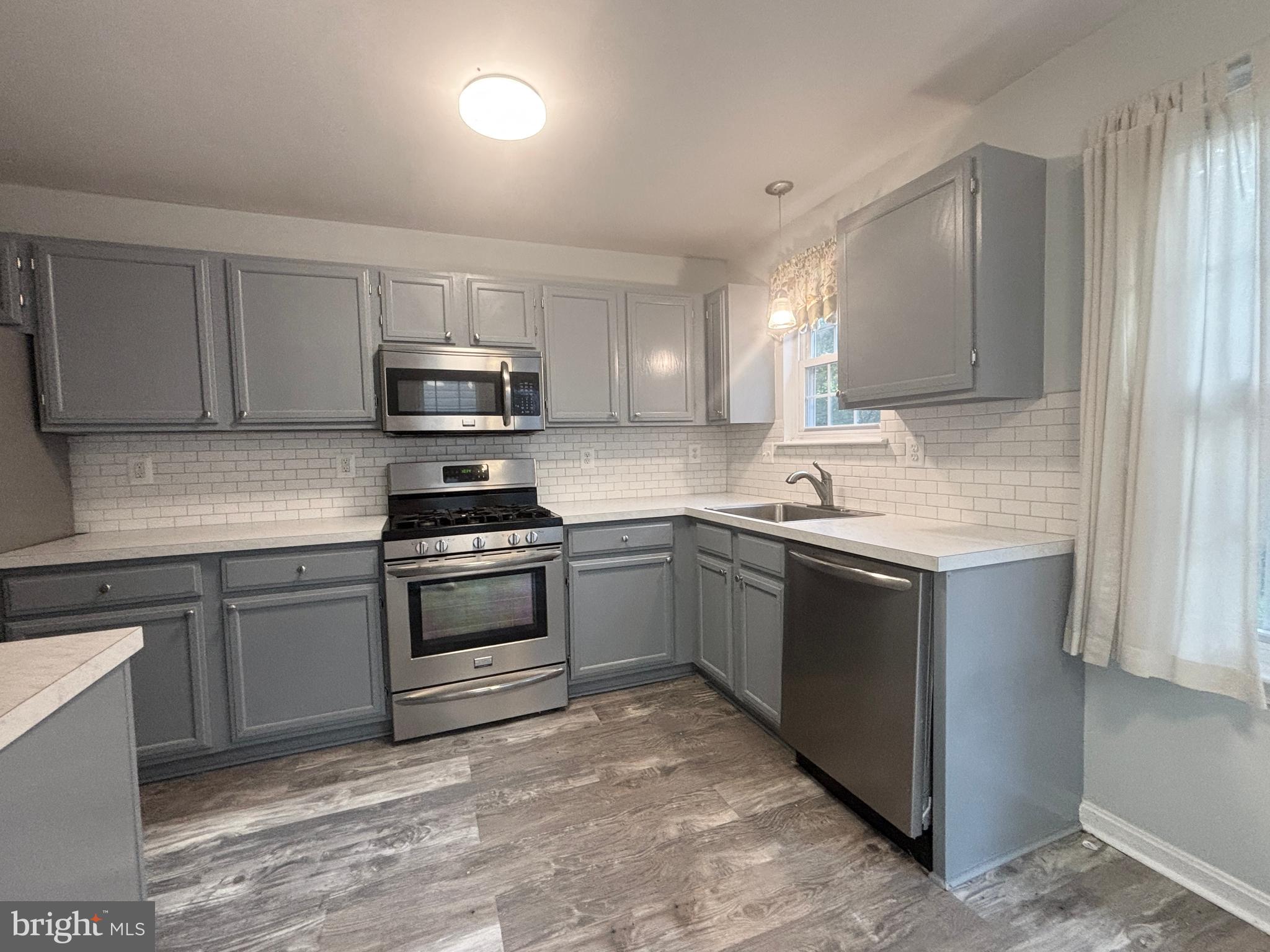 307 Tall Pines Court, Unit 3 Abingdon, MD 21009 - Photo 15 of 52 a kitchen with sink a microwave and cabinets