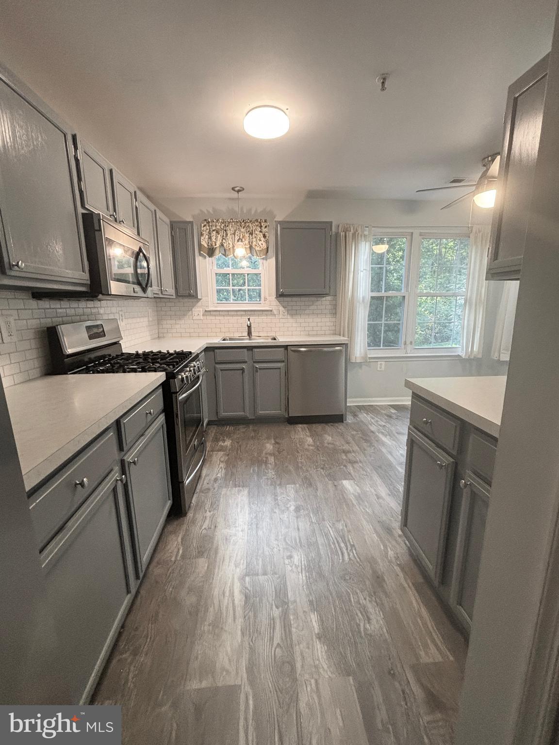 307 Tall Pines Court, Unit 3 Abingdon, MD 21009 - Photo 17 of 52 a large kitchen with a wooden floor and a stove top oven