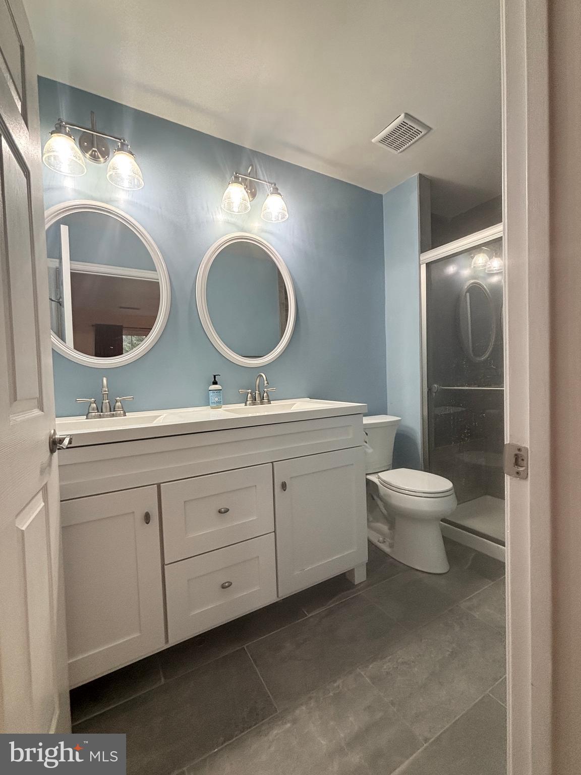 307 Tall Pines Court, Unit 3 Abingdon, MD 21009 - Photo 31 of 52 a bathroom with a toilet a double vanity sink and mirror