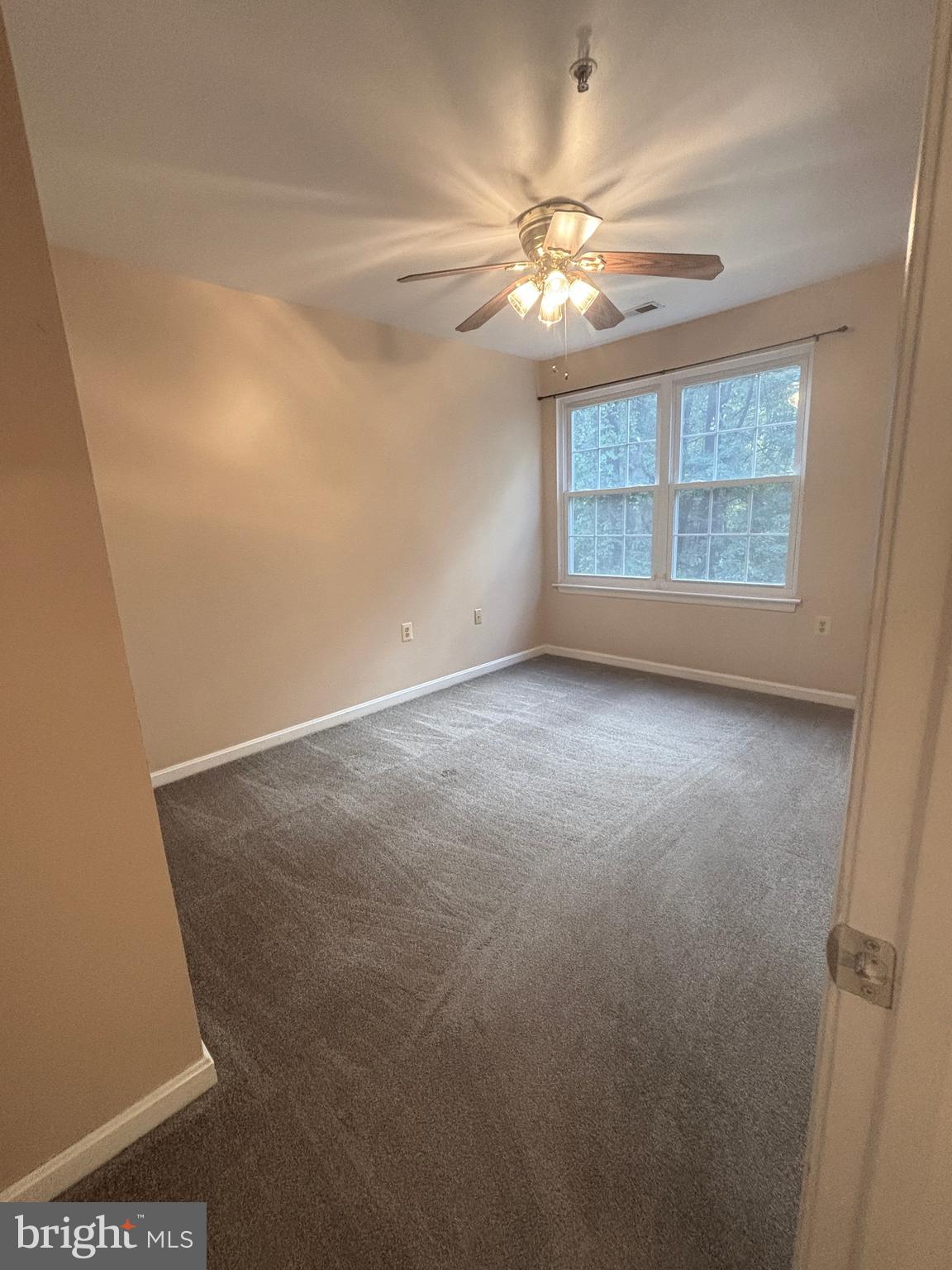 307 Tall Pines Court, Unit 3 Abingdon, MD 21009 - Photo 34 of 52 en empty room with windows and chandelier fan