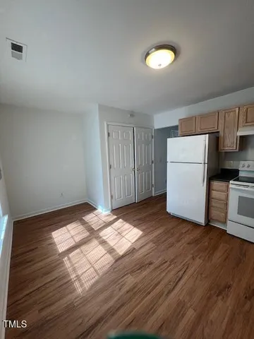 a view of empty room with wooden floor and window