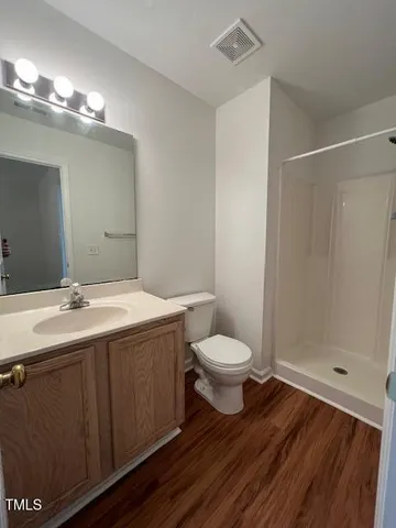 a bathroom with a sink a toilet a mirror and shower