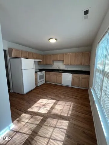 a view of a refrigerator in kitchen and a window