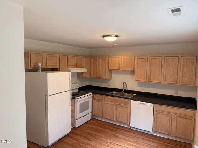a kitchen with granite countertop white cabinets and white appliances