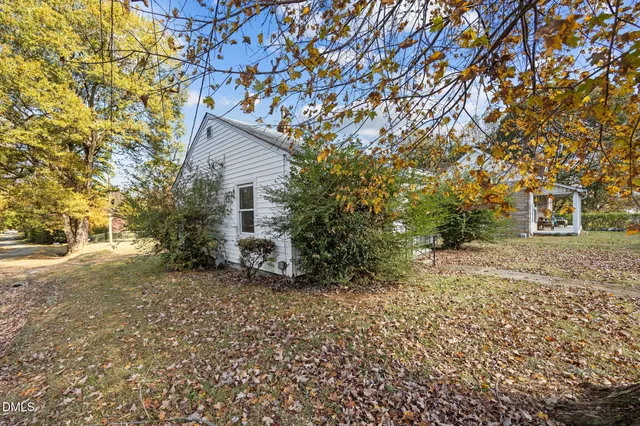 a backyard of a house with large trees and brick walls
