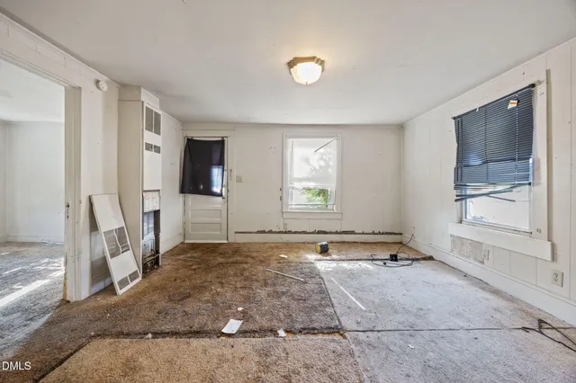 a view of an empty room with a fireplace and a window