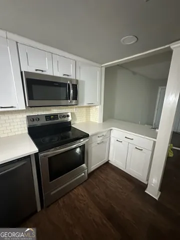 a kitchen with white cabinets stainless steel appliances and sink