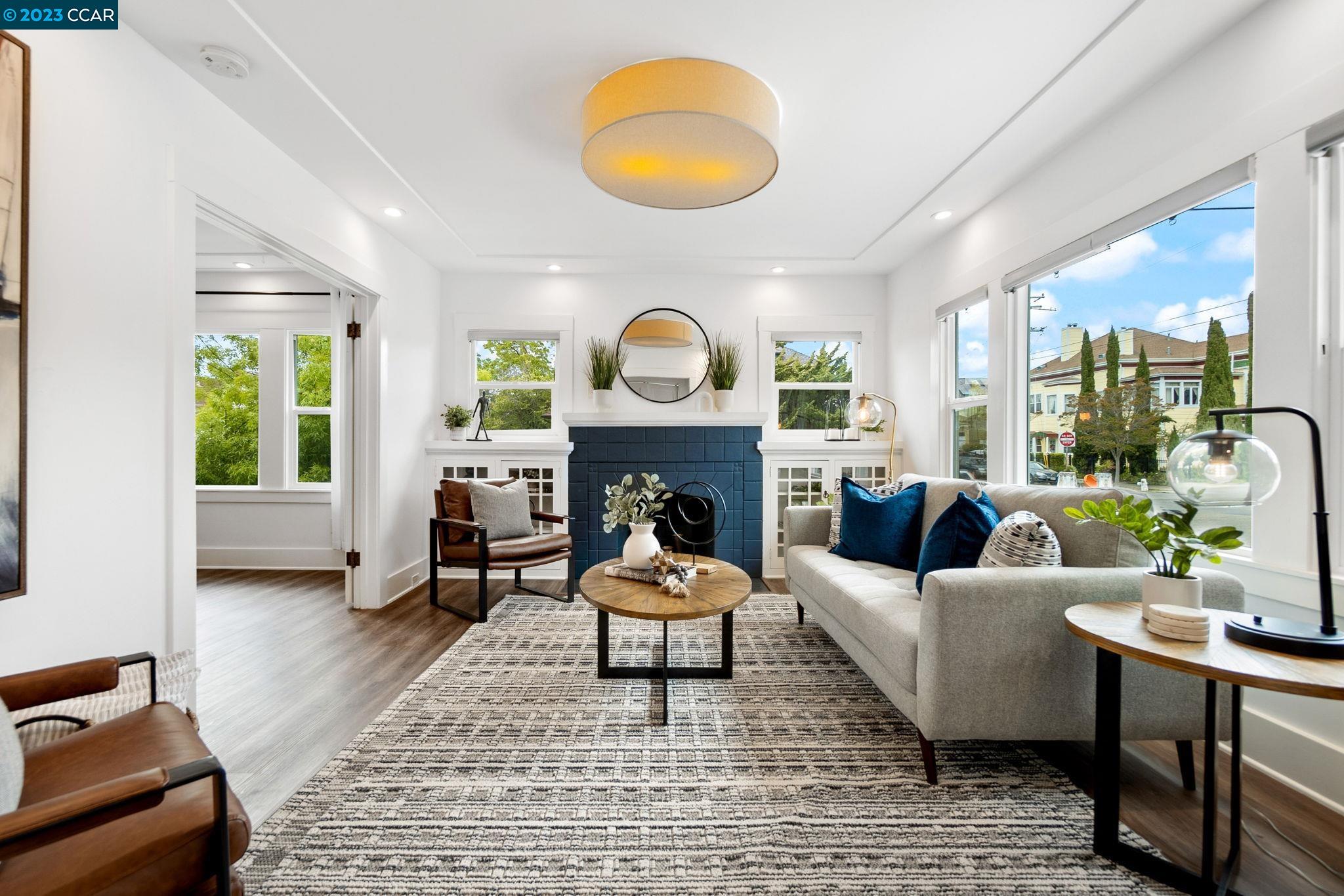 a living room with furniture a fireplace and a large window