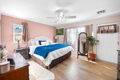 a bedroom with a bed and wooden floor